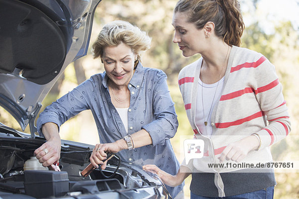 Mother and daughter jump starting car