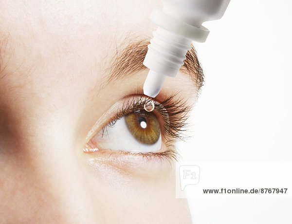 Extreme Nahaufnahme der Frau beim Einführen von Augentropfen in das Auge