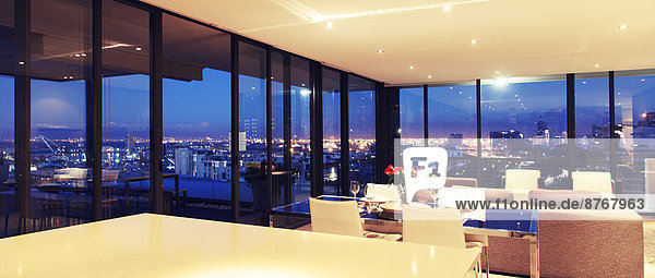 Illuminated modern living room overlooking city