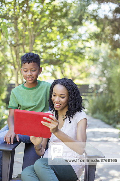 Mutter und Sohn mit digitalem Tablett im Freien