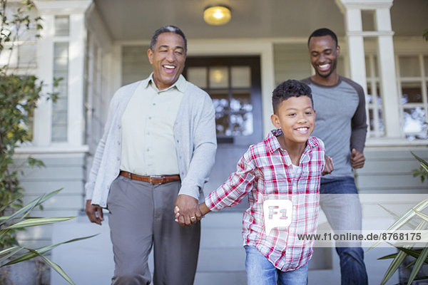 Mehrgenerationen-Männer halten Händchen vor dem Haus
