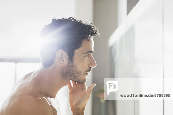 Mann überprüft Bart im Badezimmerspiegel