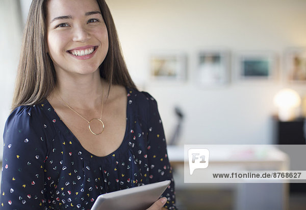 Porträt einer lächelnden Geschäftsfrau mit digitalem Tablett im Büro