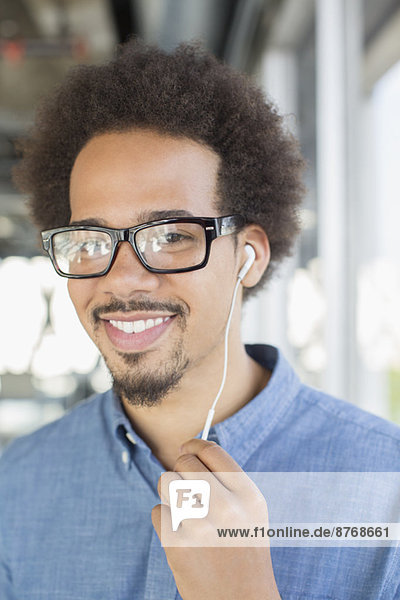 Close up portrait of man in eyeglasses using hands-free device