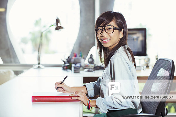 Porträt einer selbstbewussten Geschäftsfrau am Schreibtisch