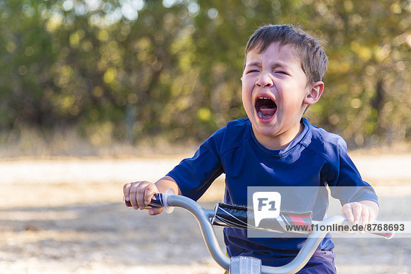 USA  Texas  Verzweifelter Junge auf dem Fahrrad