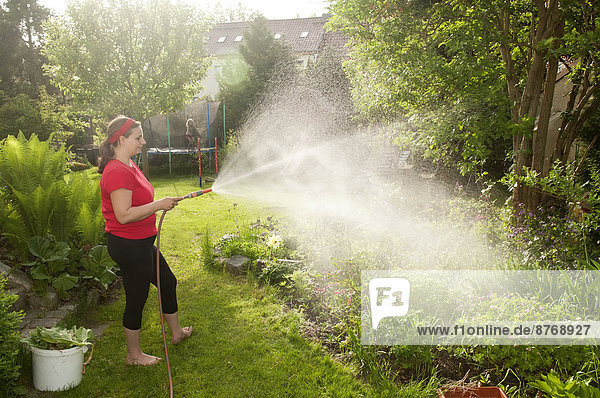 Frau in Gartenbewässerungsanlagen