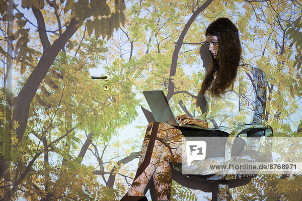 Junge Frau in der Natur Projektion mit Laptop