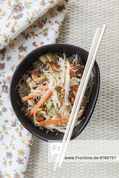 Wok dish with white cabbage  carrots  leek  egg and rice noodles