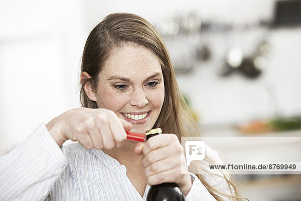 Young woman opening bottle of beer