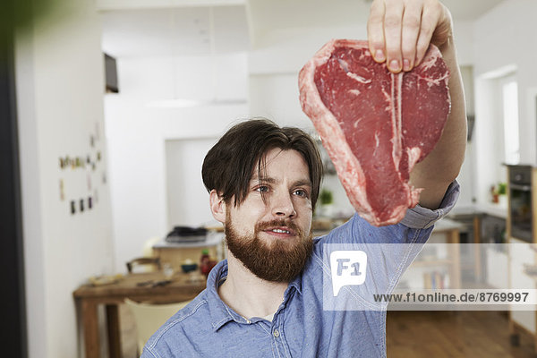 Mann in der Küche mit Steak