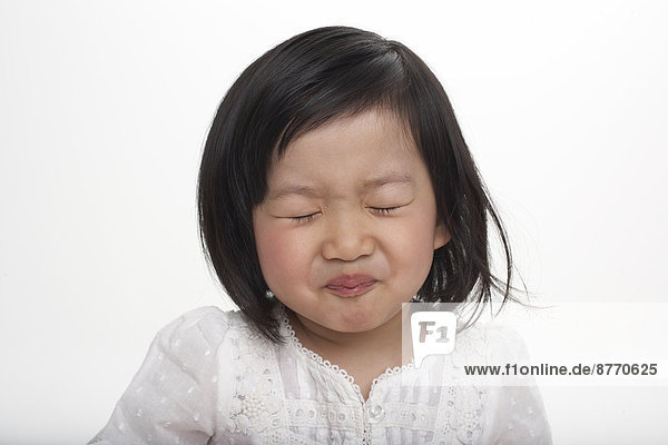 Little Asian girl holding breath  studio shot