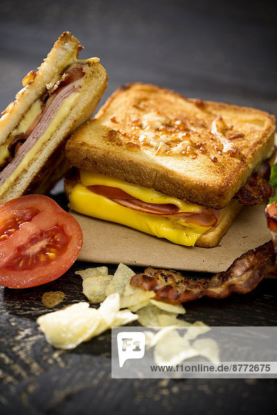 Sandwich mit Käse  Schinken  Speck und Tomaten