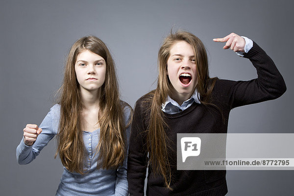 Two furious teenage girls side by side