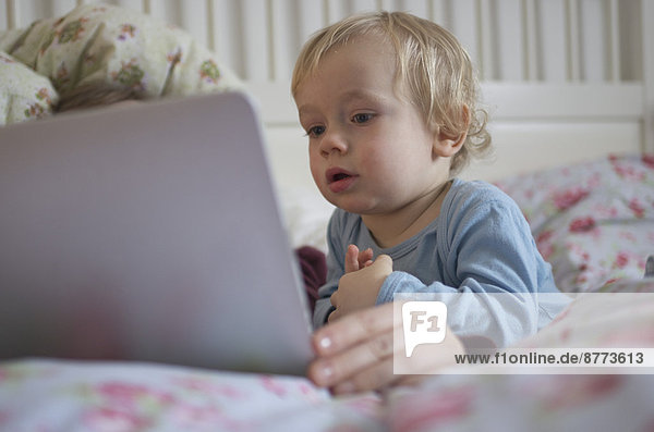 Kleinkind betrachtet digitales Tablett