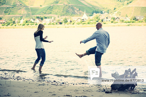 Young couple having fun at waterside of Rhine river