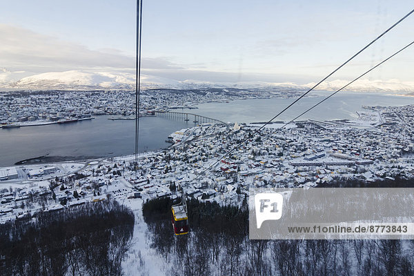 Norwegen  Troms  Tromso  Blick von Storsteinen  Seilbahn  Stadtbild  Tromsobrücke im Winter