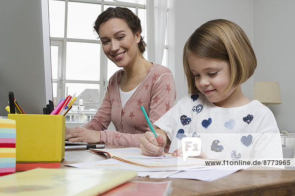Mother with daughter at desk drawing