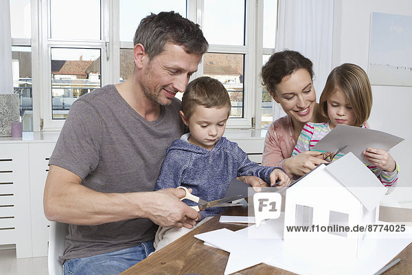 Family of four constructing house model