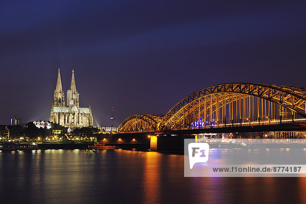 Deutschland  Nordrhein-Westfalen  Köln  Blick auf beleuchtete Hohenzollernbrücke und Kölner Dom bei Nacht