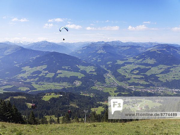 Österreich Tirol Kitzbüheler Alpen Blick von der Hohen Salve ins Brixental mit Hopfgarten Paragleiter