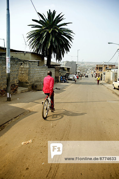 Südafrika  Johannesburg  Township Alexandra  Mann auf dem Fahrrad