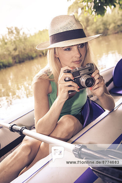 Blond woman with camera in a boat