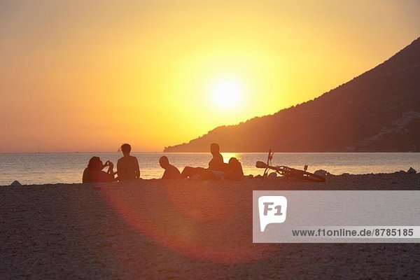 Kleine Gruppe von Leuten  die den Sonnenuntergang am Strand beobachten  Vigan  Kroatien