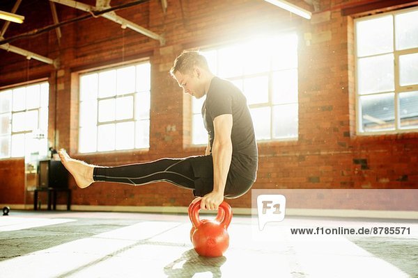 Man strength training with kettle bells