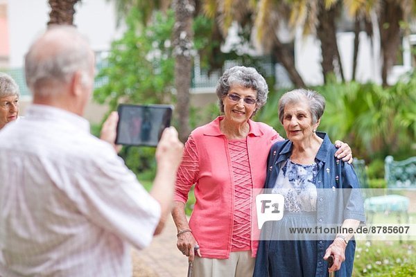 Senior Mann fotografiert Freunde im Ruhestand Villa Garten