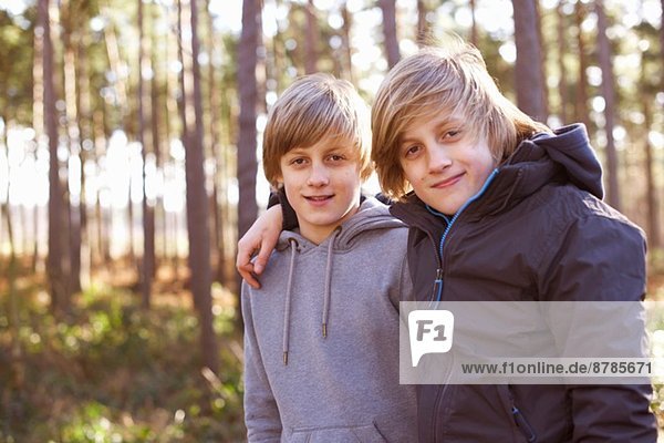 Portrait of twin brothers in forest