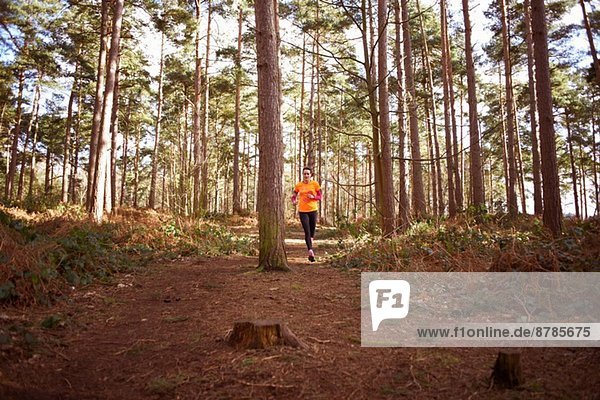 Mature woman running through a forest