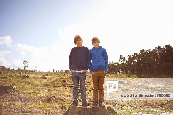 Portrait of twin brothers in forest clearing