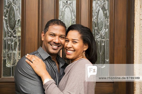 Porträt des glücklichen mittleren Erwachsenenpaares vor der Haustür
