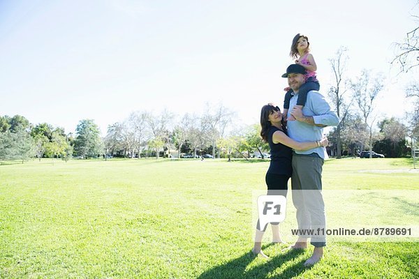 Mittleres erwachsenes Paar genießt den Park mit kleiner Tochter