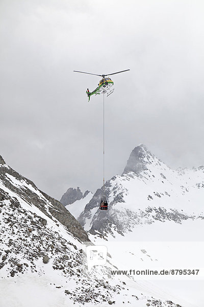 Mit dem Helikopter werden Versorgungsgüter in einem Transportnetz über den Cavardiras-Gletscher zur Cavardiras-Hütte geflogen  Graubünden  Schweiz