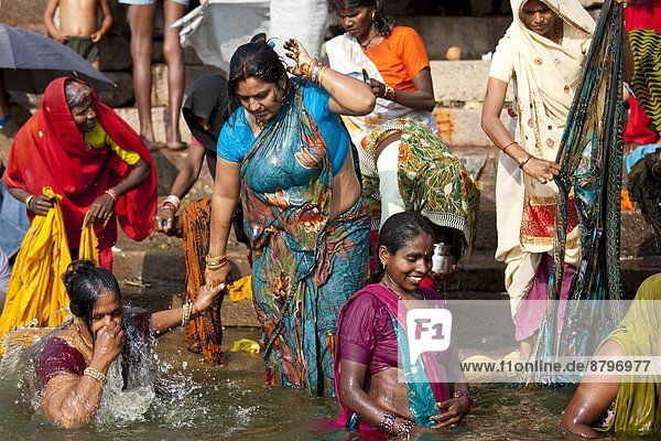 Indian Hindu pilgrims bathing in The Ganges River at Dashashwamedh Ghat in Holy City of Varanasi  Benares  India