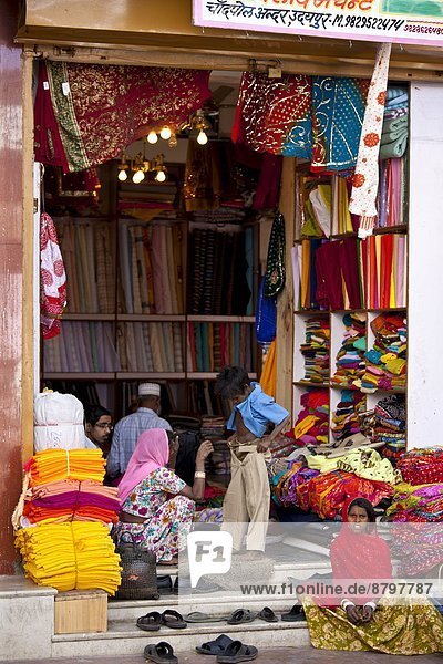 Indian family shopping for children's clothes in old town in Udaipur  Rajasthan  Western India