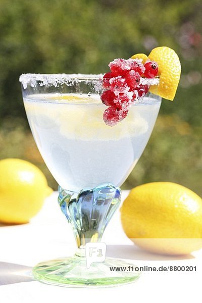'Cold Duck' punch in a glass with a sugared rim  decorated with a heart made from lemon peel and with candied redcurrants