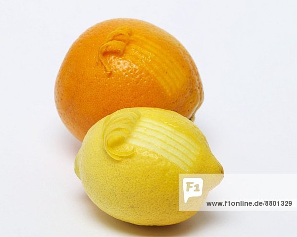 An orange and a lemon with curling zest