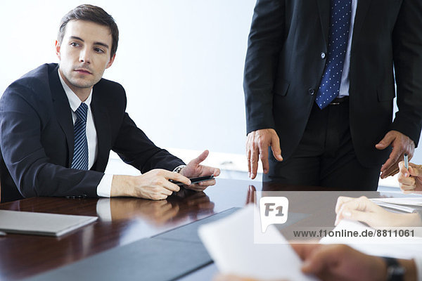 Businessman listening to collegues speak during meeting