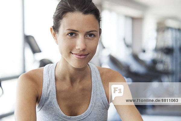 Young woman using exercise machine at gym