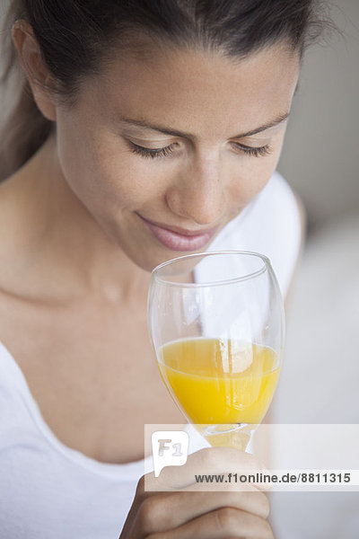 Junge Frau trinkt ein Glas Orangensaft