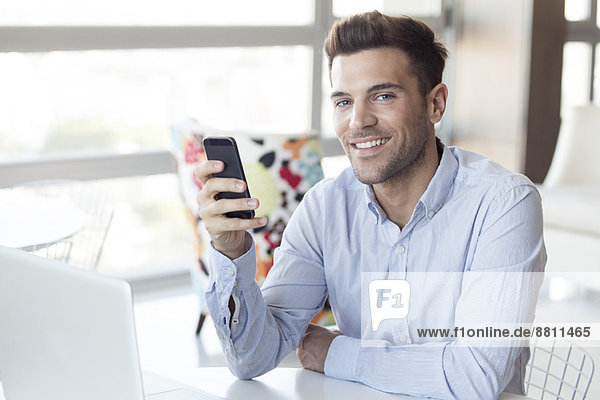Man with look of satisfaction holding smartphone