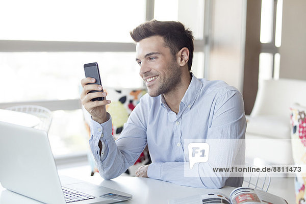 Man with expression of happiness looking at smartphone