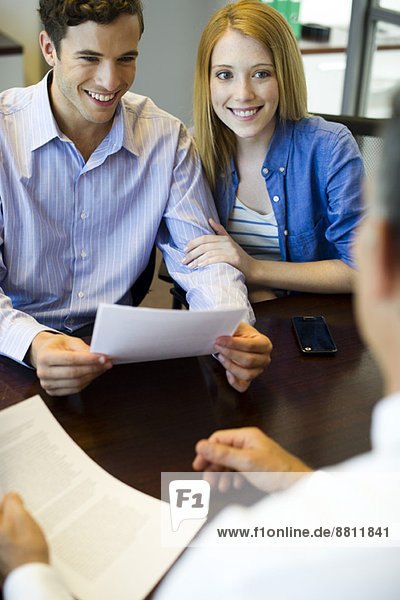 Couple reviewing paperwork in meeting with advisor
