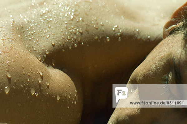 Mann beim Sonnenbaden  Wassertropfen auf der Schulter  extreme Nahaufnahme