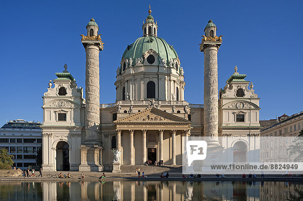 Barocke Karlskirche 1739 fertiggestellt  mit Spiegelung im Tilgner Brunnen  die Säulen zeigen in einem Spiralrelief Motive aus dem Leben Karl Borromäus'  Wien  Land Wien  Österreich
