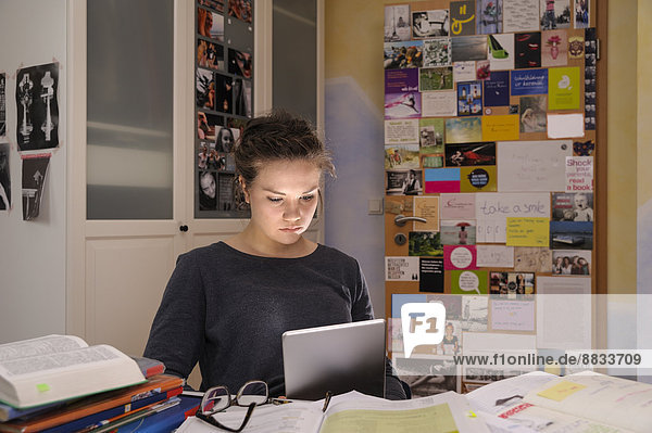 Female pupil doing homework with digital tablet