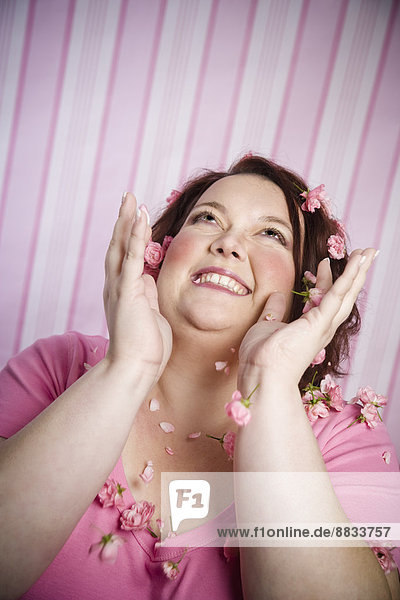 Porträt einer lächelnden Frau mit rosa Blumen